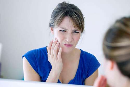 chica con dolor a causa de la gingivitis