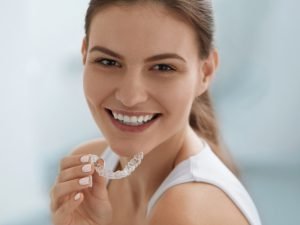 Paciente mostrando su retenedor dental tras tratamiento de ortodoncia